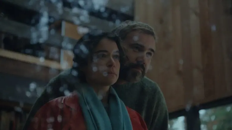 لیز و مالکم به‌صورت تهدیدآمیز از پنجره به بیرون نگاه می‌کنند در فیلم «Keeper»